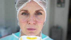 Female doctor during a coronavirus pandemic covid-19 takes off glasses and a protective mask, face marks are visible from the mask, red spots. Close portrait of a tired doctor - Powered by Shutterstock - Get 15% off with code: PIKWIZARD15