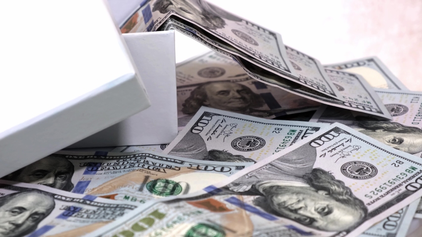 Many of 100 American Dollars Banknotes in Gift Box Isolated on a White Rotating Table.