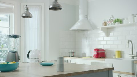 Cozy Modern Scandinavian Kitchen Interior with Electrical Appliances and Fruits. Empty Sunny Room with Wireless Speaker, Coffee Machine, Kettle and Toaster on a Wooden Table. Winter Snow Outside.
