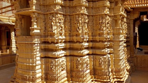 JAISALMER, RAJASTHAN / INDIA - Oct 20, 2019: elaborate and intricately carved wall from golden stone at the Parshwanath jain temple. Tilt Up