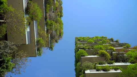 Milan, Italy, May 2, 2020: modern and ecological skyscrapers with many trees on each balcony. Bosco Verticale. Modern architecture, vertical gardens, terraces with plants. Green Planet. Blue sky