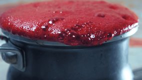 red froth pours out of the pan. making berry syrup. - Powered by Shutterstock - Get 15% off with code: PIKWIZARD15