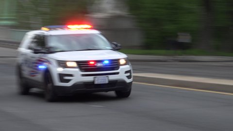 WASHINGTON, DC - MAY 1, 2020: Lights flashing, siren wailing, DC police car races past, responding. DC is covered by numerous law enforcement agencies.