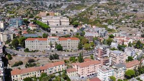 Drone flight over beautiful italian city. View of churches and houses with red tiled roofs. San Remo, Italy. Aerial view in 4K