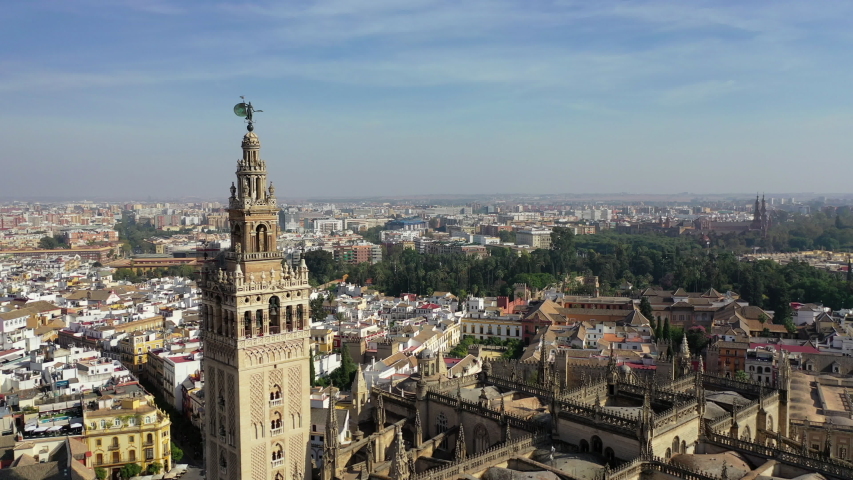 Aerial shot of famous cathedral by tourists in city on sunny day, drone flying over religious building against sky - Seville, Spain | Shutterstock HD Video #1051586848