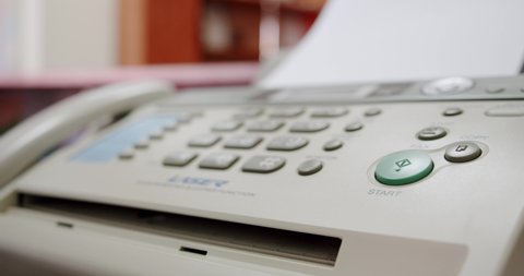 Close up Hand of a woman using fax, presses the button and picks up the phone,