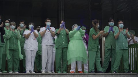 MADRID, SPAIN - APRIL 4 2020. Medical staff from 12 de Octubre hospital who are fighting coronavirus applaud back the people of Madrid and police officers for their support