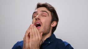 Close up sick man sneezing on white background. Ill guy with cold symptoms sneezing in studio. Portrait of sick student sneezing from allergy in slow motion. Ill man feeling bad - Powered by Shutterstock - Get 15% off with code: PIKWIZARD15