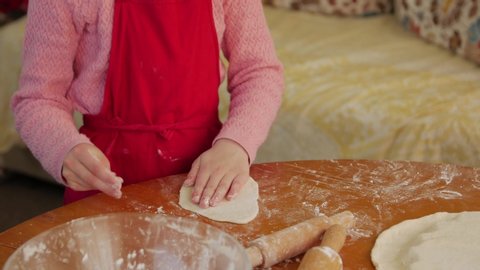 Little girl cooking dough rolling homemade pizza closeup camera movement