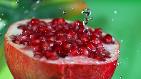 Super Slow Motion Shot of Pouring Water on Fresh Pomegranate at 1000fps.