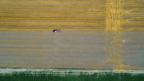 Aerial view of agricultural corn, wheat and sunflower fields with machinery during tillage, cultivation and harvest
