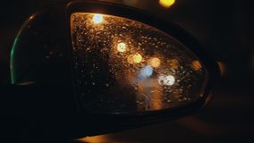 Wet side mirror of an automobile while moving - riding at rainy night