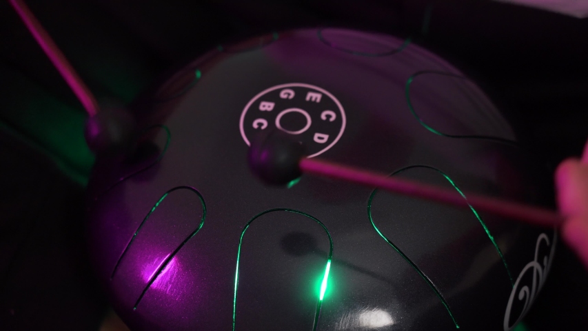 a man sits at home and plays around on the hapi drum warm atmosphere on isolation