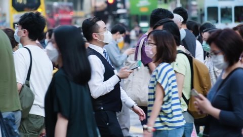 Hong Kong - May 3, 2020: Slow motion of crowd people wearing medical face masks in Hong Kong. Coronavirus concept