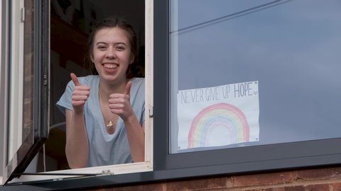 Rainbow Poster For The NHS - Teenage Girl Thumbs Up In House Window With Rainbow Sign In Window - Never Give Up Hope