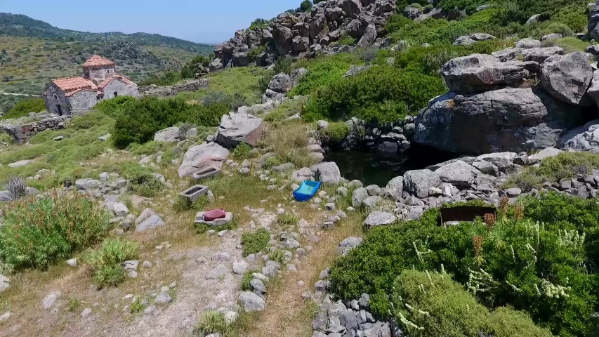 An old stone handmade water tank and the Temple of Hellanios  Zeus in Aegina Island Greece.