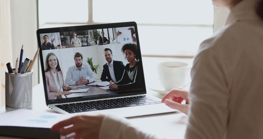 Business woman video conference calling diverse ethnicity office team by webcam working from home discussing project report data at virtual group conference meeting. Over shoulder laptop screen view. Royalty-Free Stock Footage #1051686106