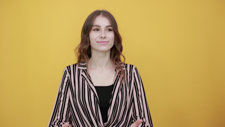 Cute Young Woman Light Brown In Striped Pink And Black Shirt On A Yellow Background, Happy Girl Smiles And Reaches For Hug