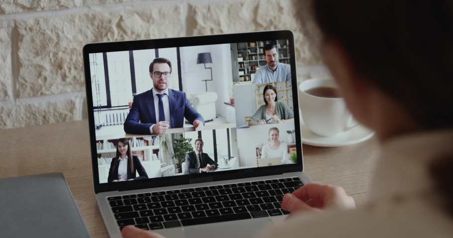 Over shoulder closeup view of remote employee conferencing in online group virtual chat on laptop screen. Company staff colleagues and boss using pc video call app working from home office by web cam. Royalty-Free Stock Footage #1051691221