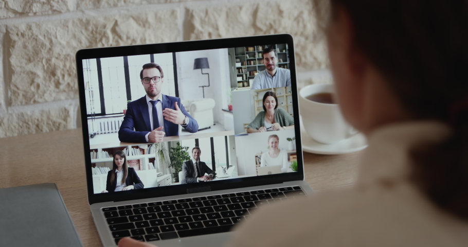 Over shoulder closeup view of remote employee conferencing in online group virtual chat on laptop screen. Company staff colleagues and boss using pc video call app working from home office by web cam. Royalty-Free Stock Footage #1051691221