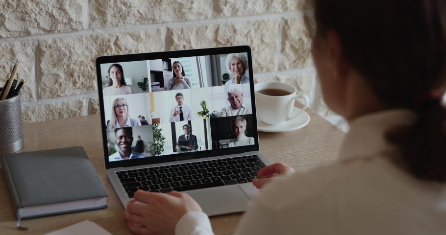 Over shoulder view of businesswoman video conferencing diverse business people team on laptop screen engaged in online group call, virtual corporate meeting using pc app for distance company teamwork. Royalty-Free Stock Footage #1051691224
