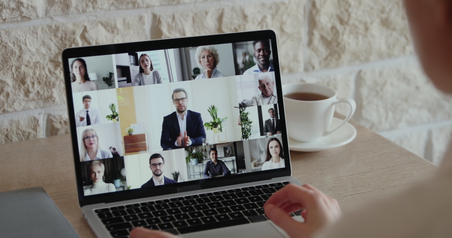 Remote work conference group call concept. Over shoulder closeup view or distance worker video conferencing boss and colleagues team participating virtual meeting using computer app from home office. Royalty-Free Stock Footage #1051691227