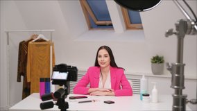 Female vlogger freelancer streams. The camera is close-up. View through the camera screen. The white room.