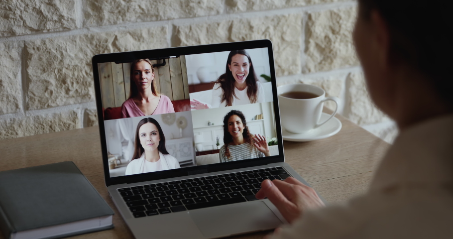 Young woman conferencing happy girls talking enjoying virtual meeting using laptop. Distance friends chatting gossiping by video call on computer in web cam videocall app. Over shoulder screen view Royalty-Free Stock Footage #1051702396
