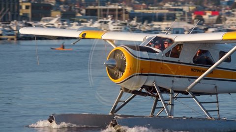 Seattle, Washington - February 2 2020: Kenmore Air seaplanes take off and land on south lake union at sunset. The amphibious planes with passengers transport people in and out of the city. 