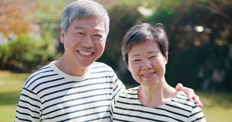Asian elderly couple smile at you happily