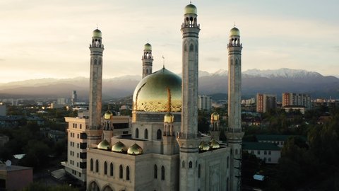 Aerial flight around mosque with gold dome at sunrise in Almaty city , Kazakhstan