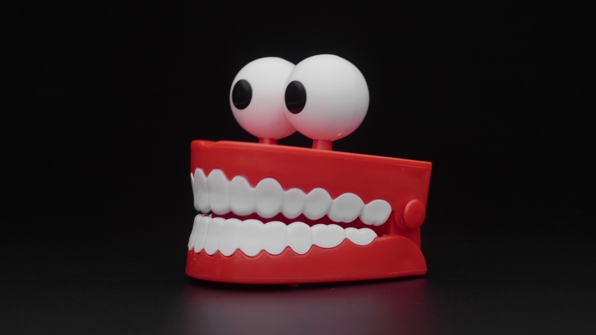 Сhattering teeth toy moving on black background. | Shutterstock HD Video #1051723492