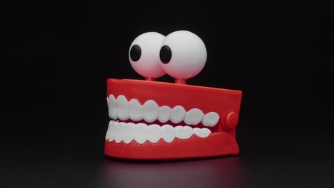 Сhattering teeth toy moving on black background.