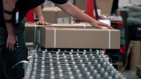 Parcels are scanned on the packaging line in a warehouse. Parcels wait on the conveyor to be shipped. Automation of online shipping logistics