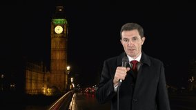 News Reporter on location with a microphone - He is reporting in front of a Big Ben in Westminster, London. Stock Video Clip Footage