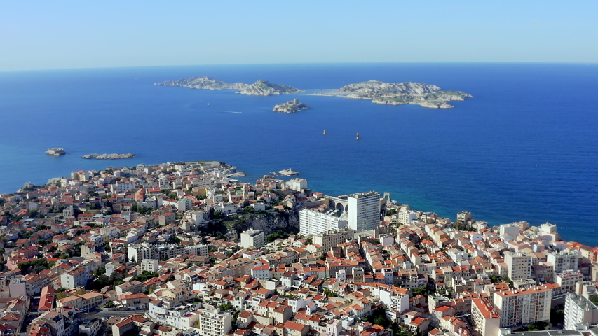 Marseille in France aerial view feat. the old city from above and islands in Mediterranean Sea on a beautiful sunny day. It is a famous travel destination and tourist attraction of Europe 