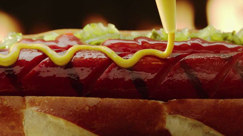 Hot Dog grilled fully dressed on hot dog bub with relish and ketchup is decorated with mustard