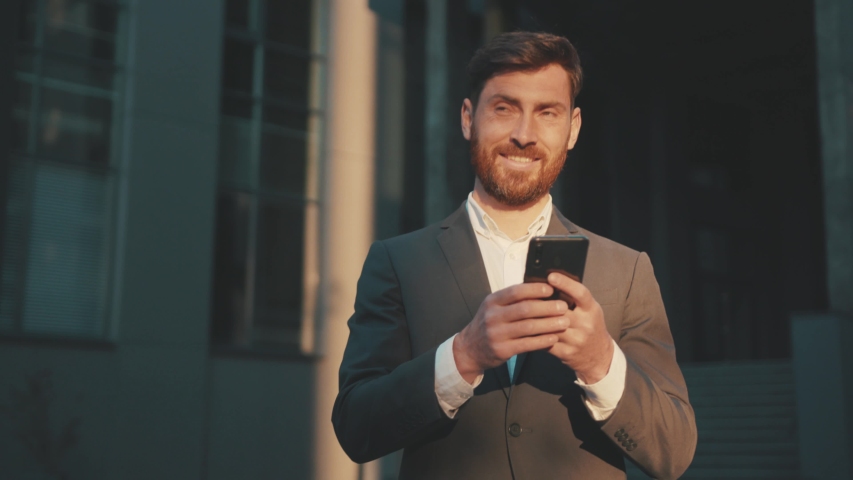 Shot move around businessman stand in the city center street uses phone texting scrolling tapping smile technology communication sunny day success slow motion Royalty-Free Stock Footage #1051756645
