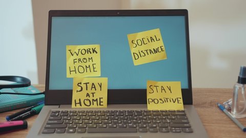 NEW YORK - March, 28, 2020: Distant workplace at laptop with reminder yellow notes stickers. Work from home. Social distance. Stay at home. Stay positive. Freelance. Quarantine.