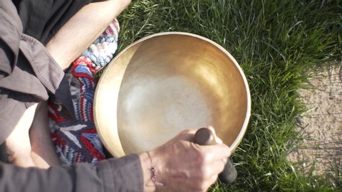 A qigong master conducts meditation using a gong and Crystal bowl, Crystal Tibetian singing bowl, a master meditates receives energy for the body
