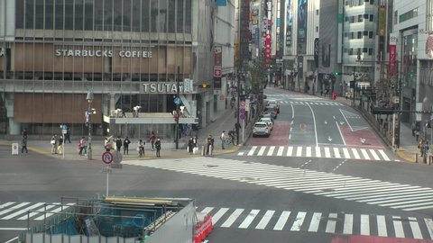 TOKYO, JAPAN -28 APRIL 2020 : View around Shibuya scramble crossing. Tokyo governor called refrain from going outside, due to concerns over Coronavirus. Street is normally busy, but lightly populated.