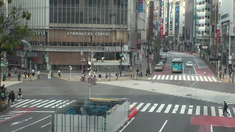 TOKYO, JAPAN -28 APRIL 2020 : View around Shibuya scramble crossing. Tokyo governor called refrain from going outside, due to concerns over Coronavirus. Street is normally busy, but lightly populated.