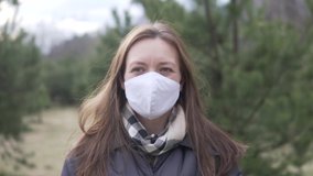 Woman takes off her surgical mask. Close-up of a masked woman in the woods - Powered by Shutterstock - Get 15% off with code: PIKWIZARD15