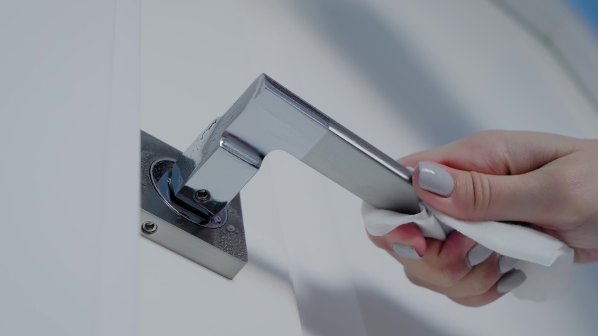 Slow motion: woman spraying antiseptic, cleaning door handle with disinfectant wet wipe - close up. Disinfection, protection, prevention, housework, COVID 19, coronavirus, safety, sanitation concept | Shutterstock HD Video #1051773967