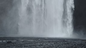 Skogafoss, Iceland - March 15 2019: Slow Motion pans of a famous waterfall in South Iceland. The waterfall is 25m across with a fall of 60m and is a popular visitor destination. 