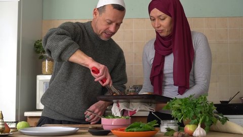A happy authentic Muslim family couple a man and a woman cook food together for iftar at home. Fasting in the Holy month of Ramadan
