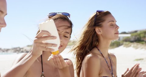 Young women applying sunscreen on body for sun protection