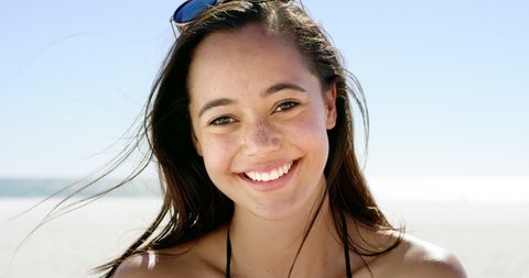 Close up portrait of beautiful young woman smiling on tropical beach slow motion