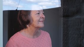 4K: Grandma seeing her Family through the window during Lockdown - Social Distancing during the COVID-19 Coronavirus Outbreak. Stock Video Clip Footage