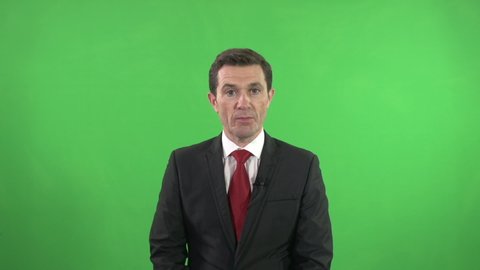 Newsreader in the Studio reading the news in front of a Green screen / Chroma key Background. Live Broadcast
